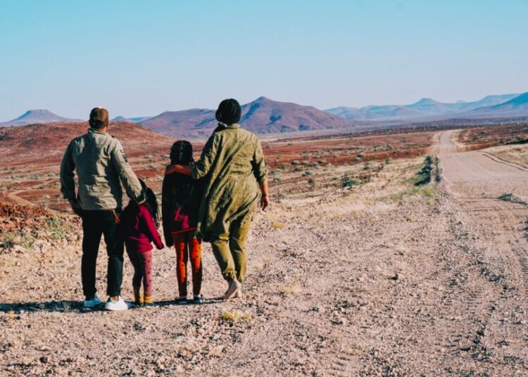 Nathalie Bonte, son compagnon et leur deux filles marchent dans le désert.