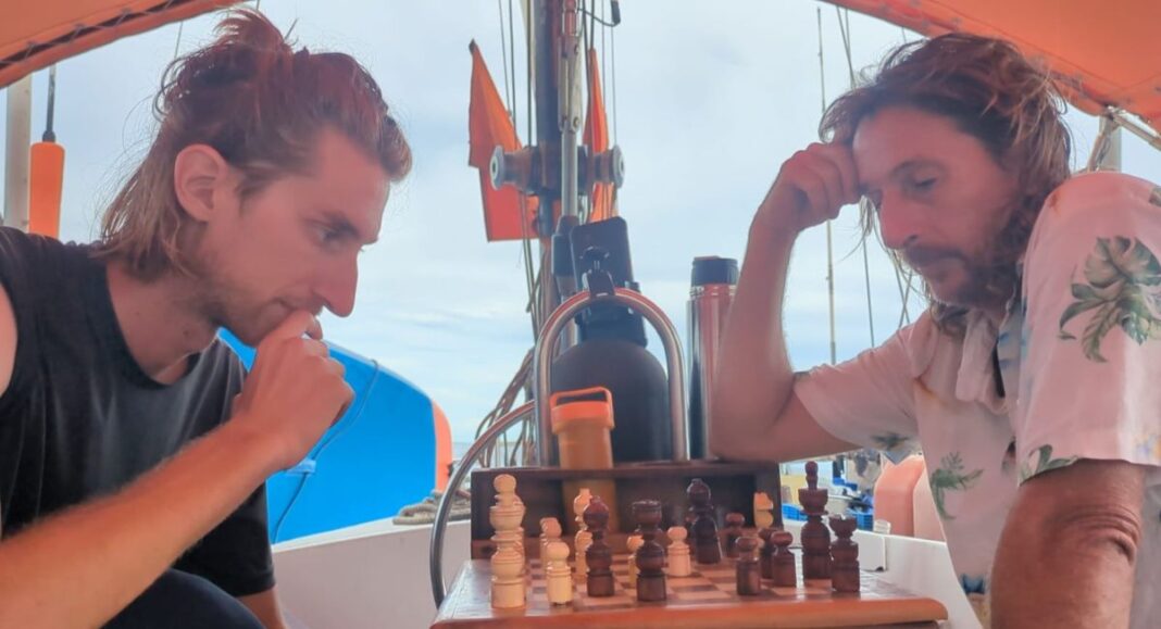 Béranger Natanelic (à gauche) en pleine traversée de l'Atlantique, joue aux échecs face à son capitaine.